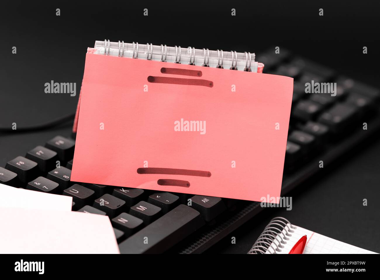 Colored sticker lying on keyboard. Important message written over paper. Stock Photo