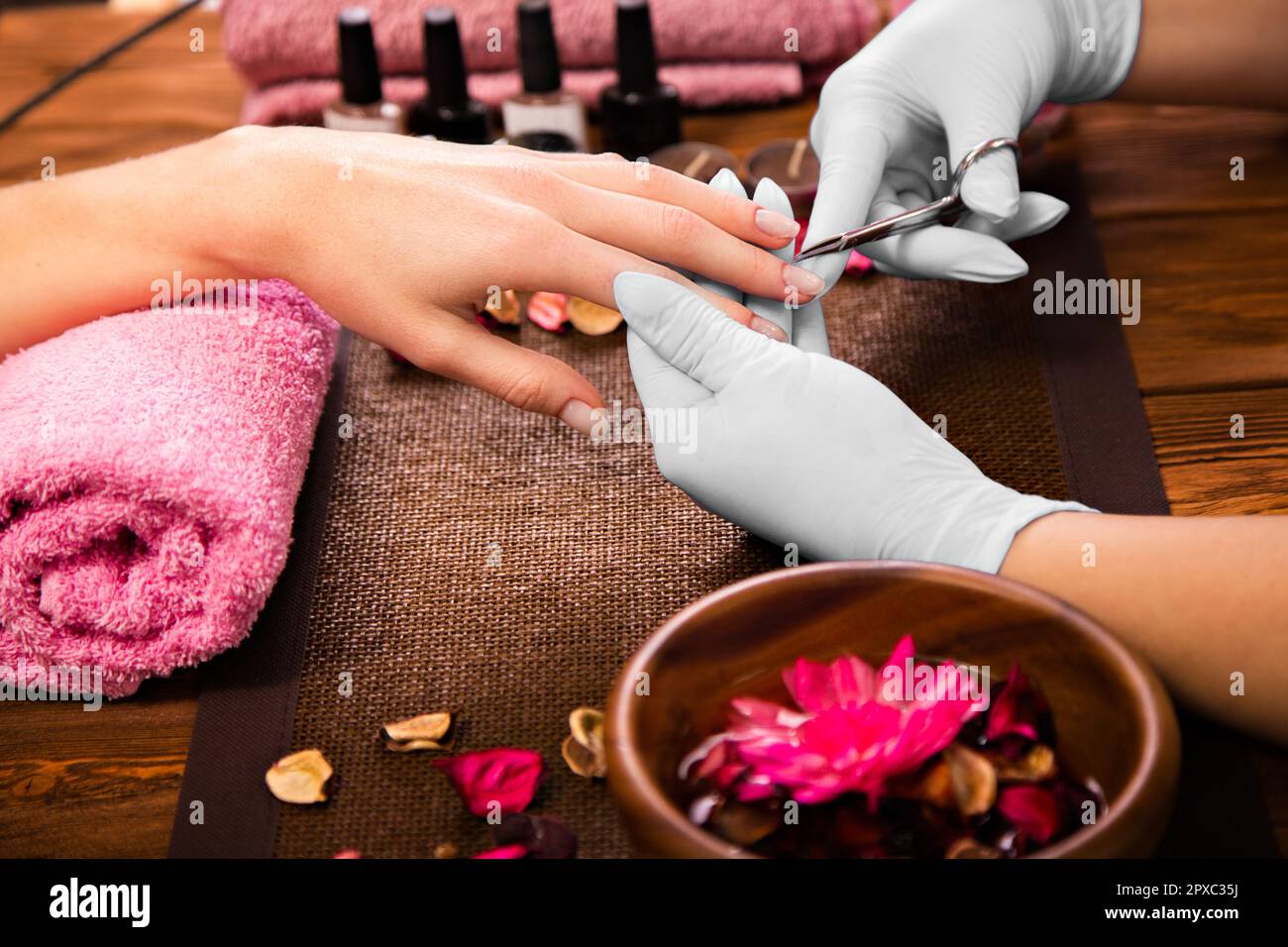 Closeup finger nail care by manicure specialist in beauty salon