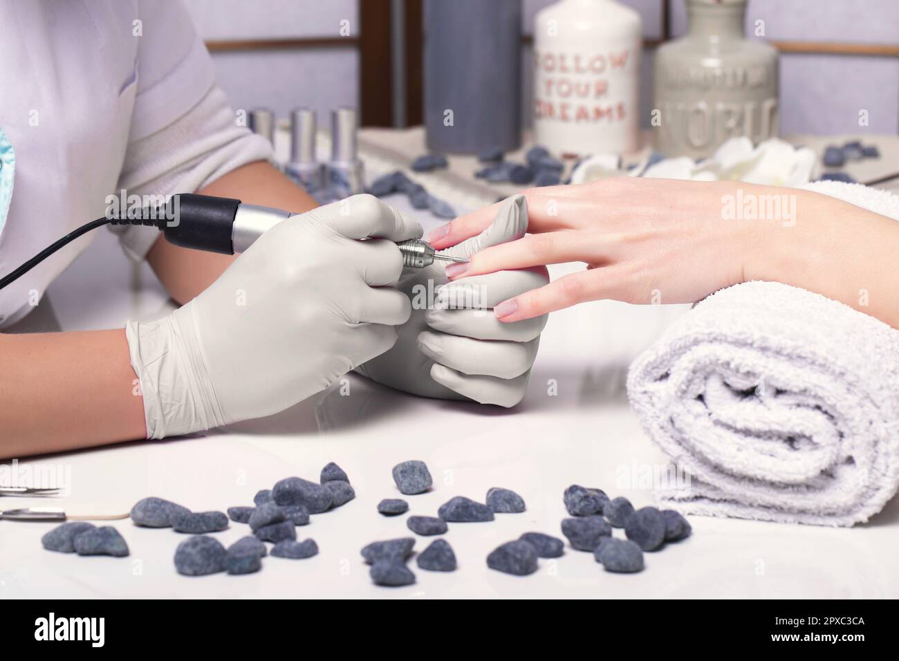 Closeup finger nail care by manicure specialist in beauty salon