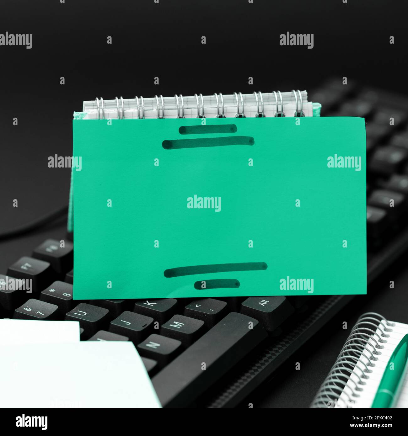 Sticker lying on black keyboard. Important message written over paper. Stock Photo