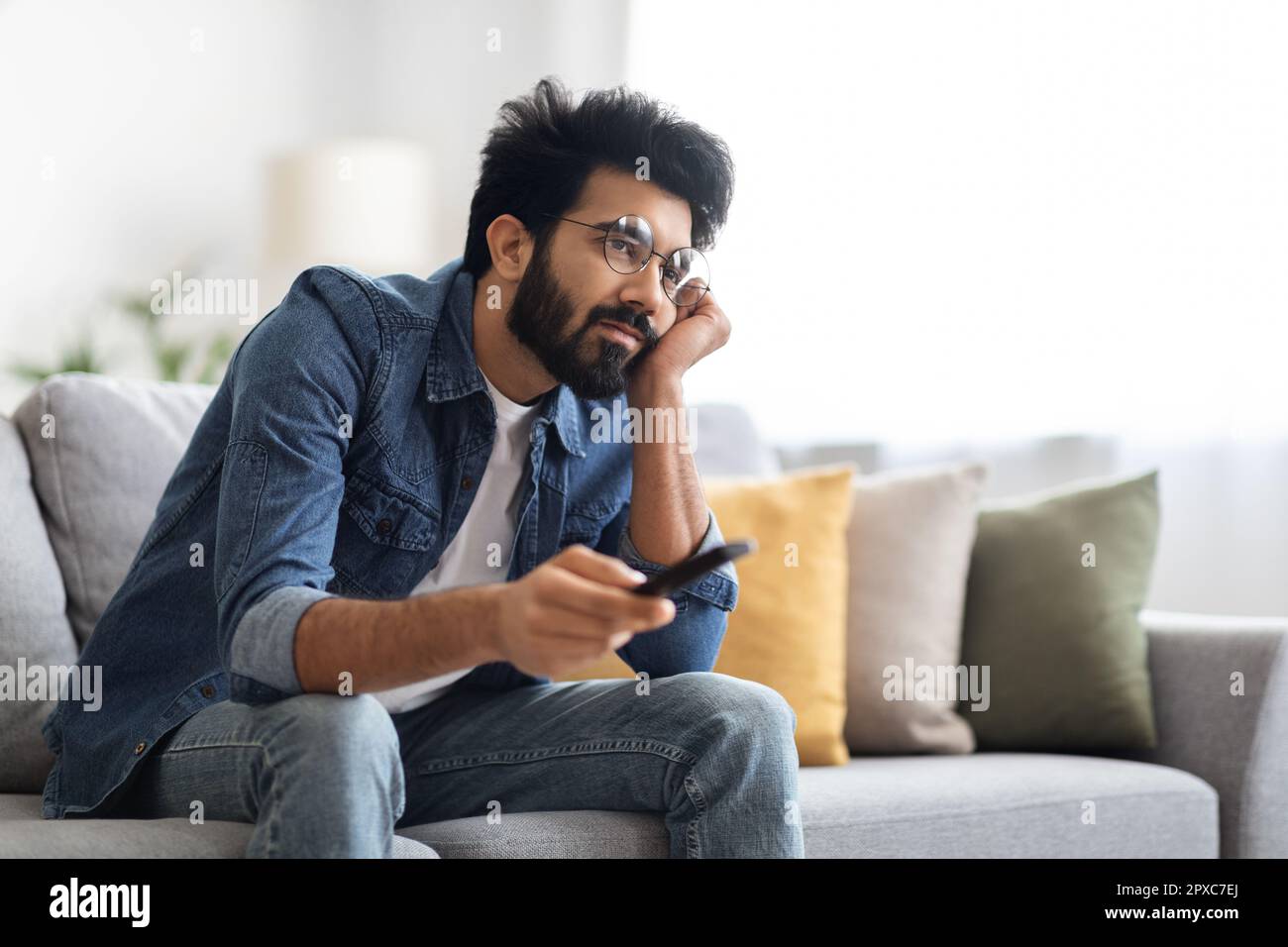Boring Show. Portrait Of Upset Young Indian Guy Watching TV At Home, Stock Photo