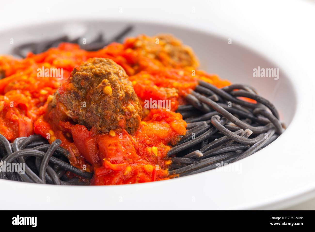 black spaghetti with tomato sauce with meat balls Stock Photo - Alamy