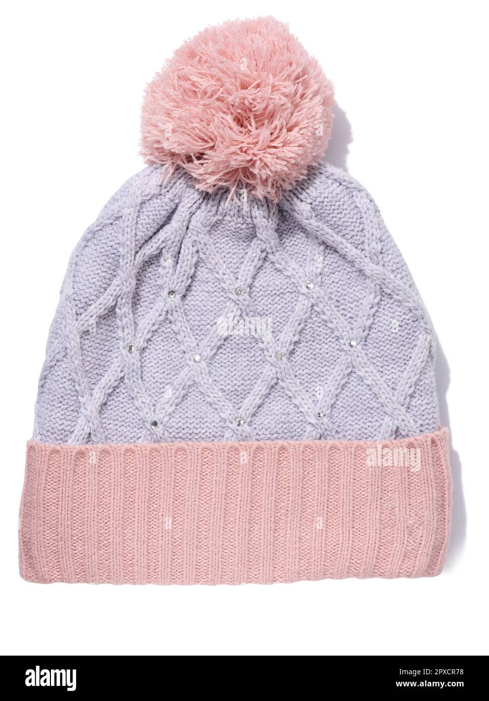 Gray-pink knitted hat with a pom-pom on a white isolated background Stock Photo