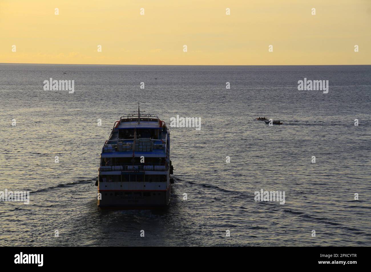 Ship out of harbor at sunset, sailing on calm seas Stock Photo Alamy