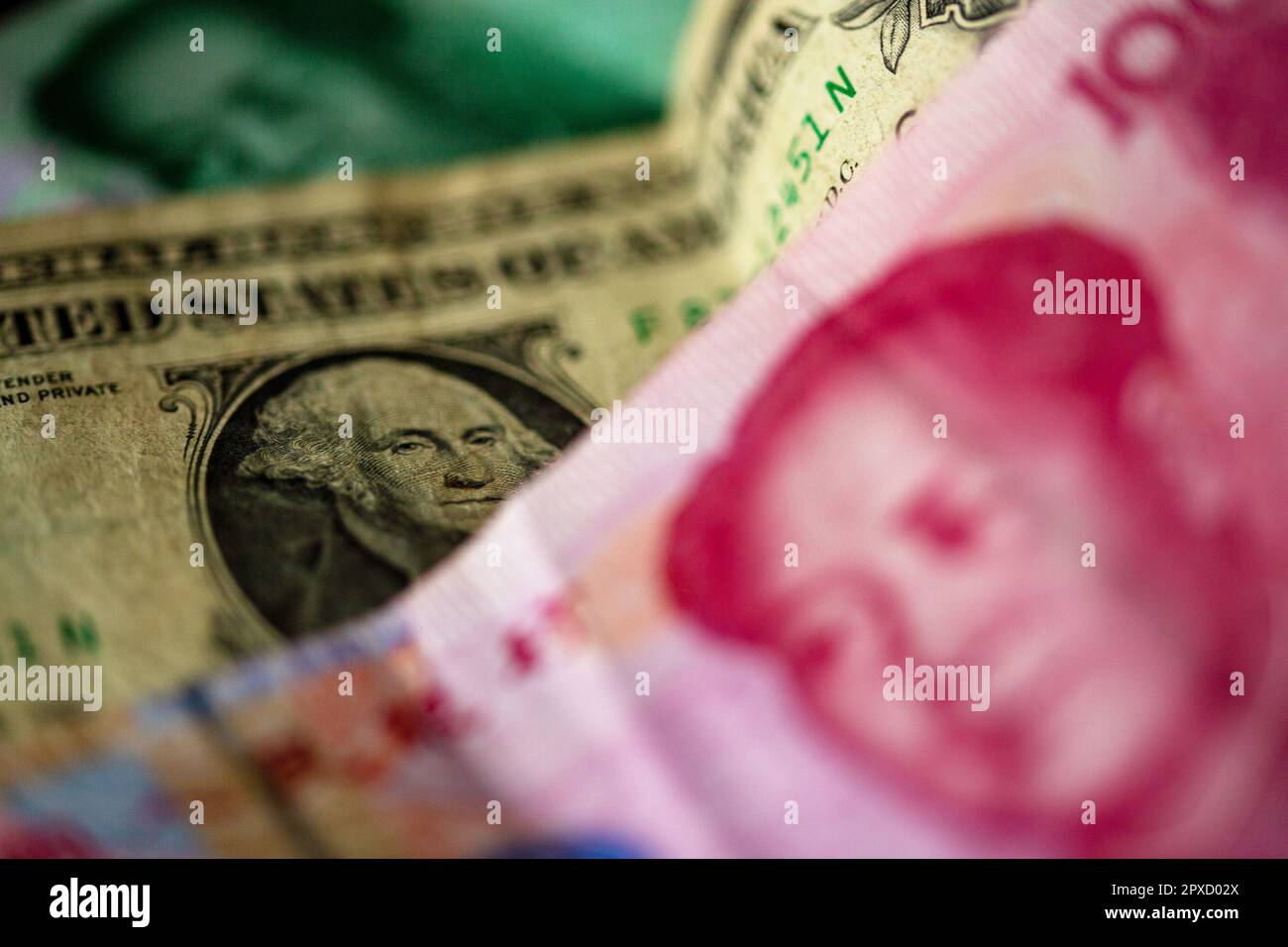 Berlin, Germany. 27th Apr, 2023. A Chinese 100 yuan banknote (front) and a 1 US dollar bill (M) are lying on a table. Credit: Fernando Gutierrez-Juarez/dpa/Alamy Live News Stock Photo