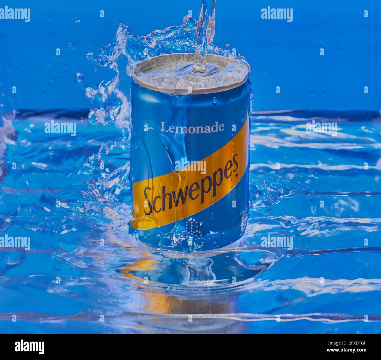 Can of Schweppes Lemonade submerged in water with water splashing over