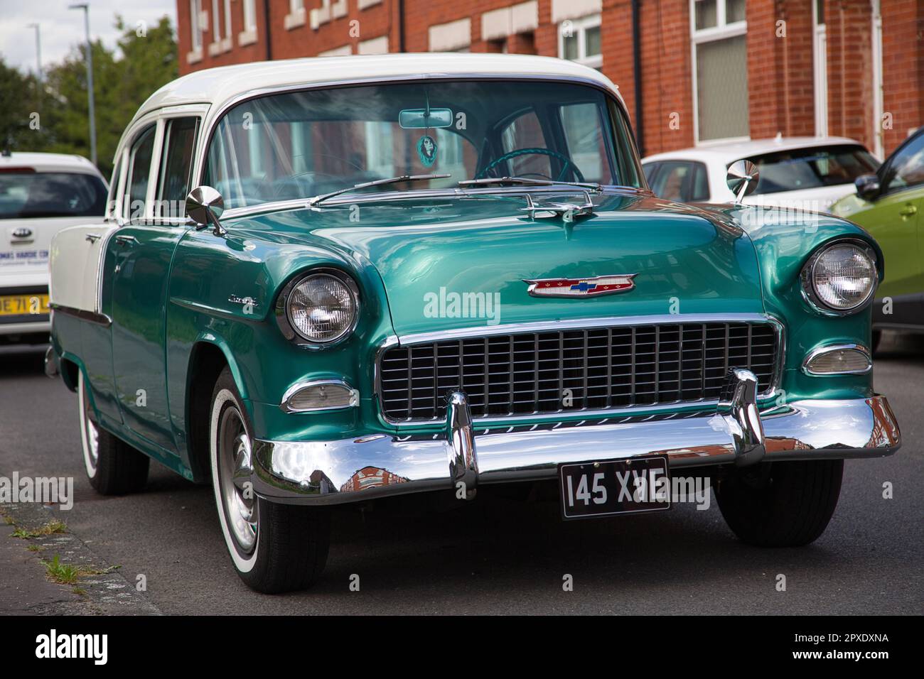 A white and green 1955 Chevrolet Bel Air parked on the street Stock