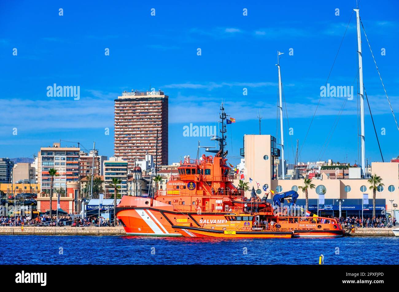 The Ocean Race, Alicante, Spain: A military ship is moored in the city port during the annual event. People are watching from onboard the vessel. Stock Photo