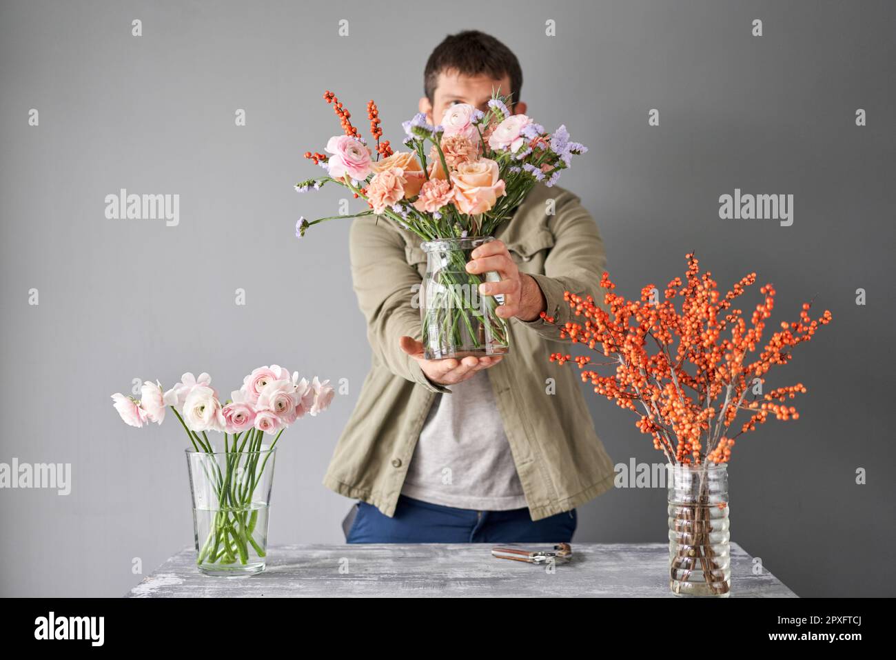 Portrait of a Male florist. Flowers bunch, set for home. Fresh cut flowers for decoration home. European floral shop. Delivery fresh cut flower. Stock Photo