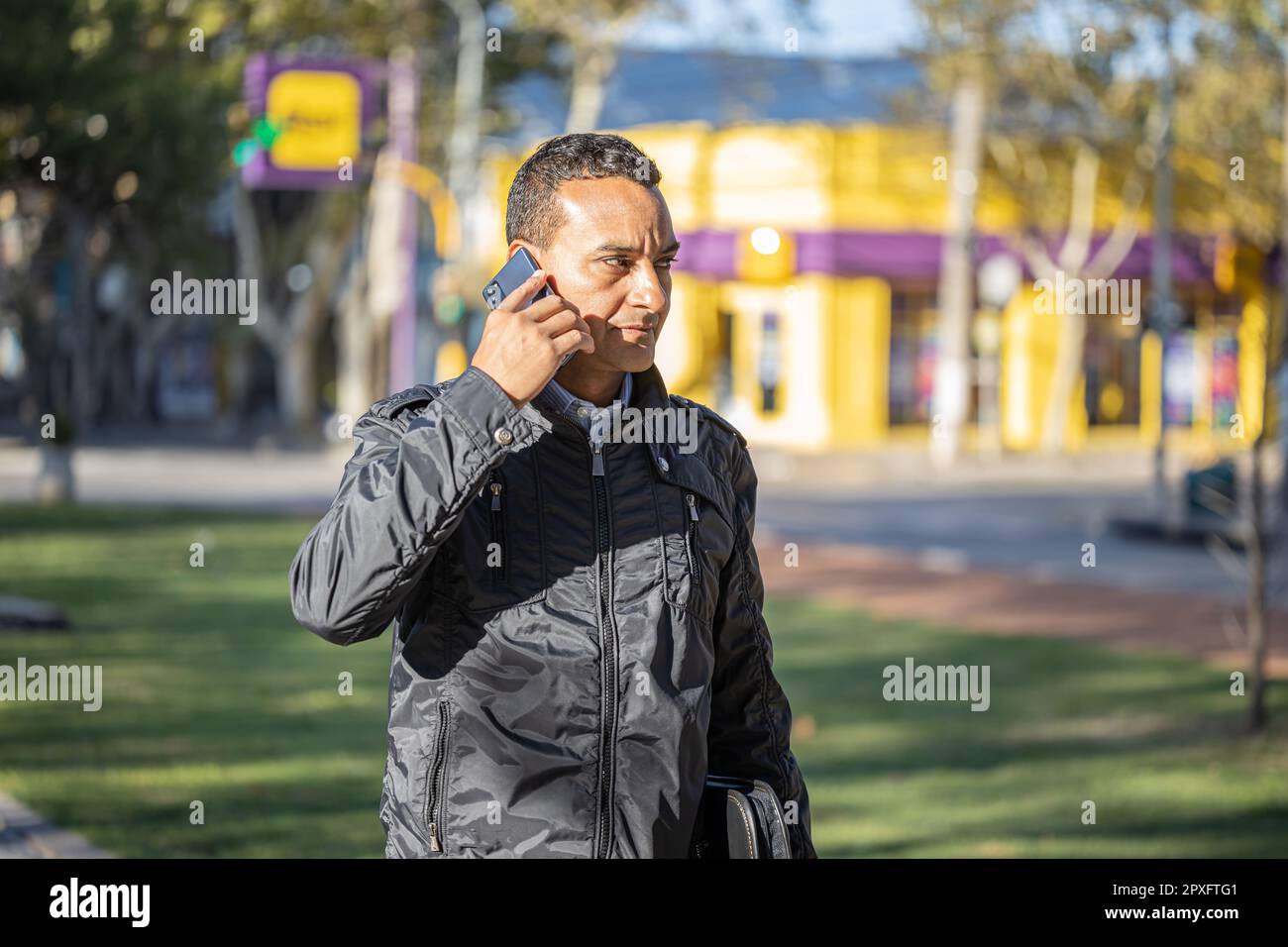 Latin young man talking on mobile phone with copy space. Stock Photo