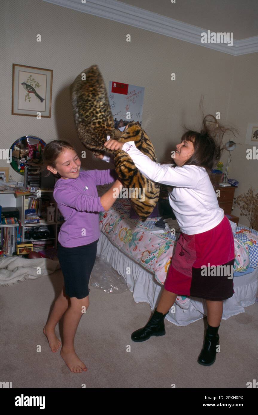 Two 9 Year Old Girls Playing Having Cushion Fight surrey england