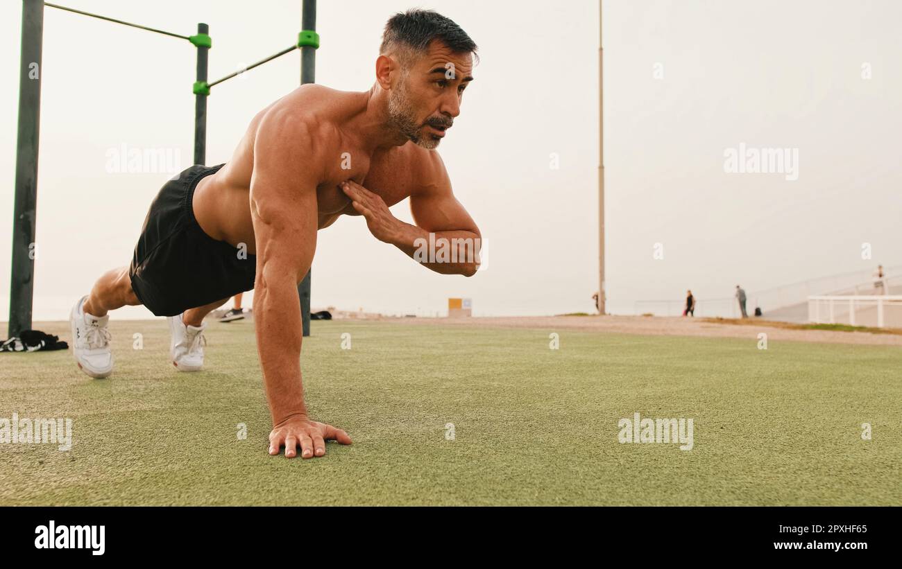 Middle aged muscular man doing push up exercises outdoors Stock Photo ...