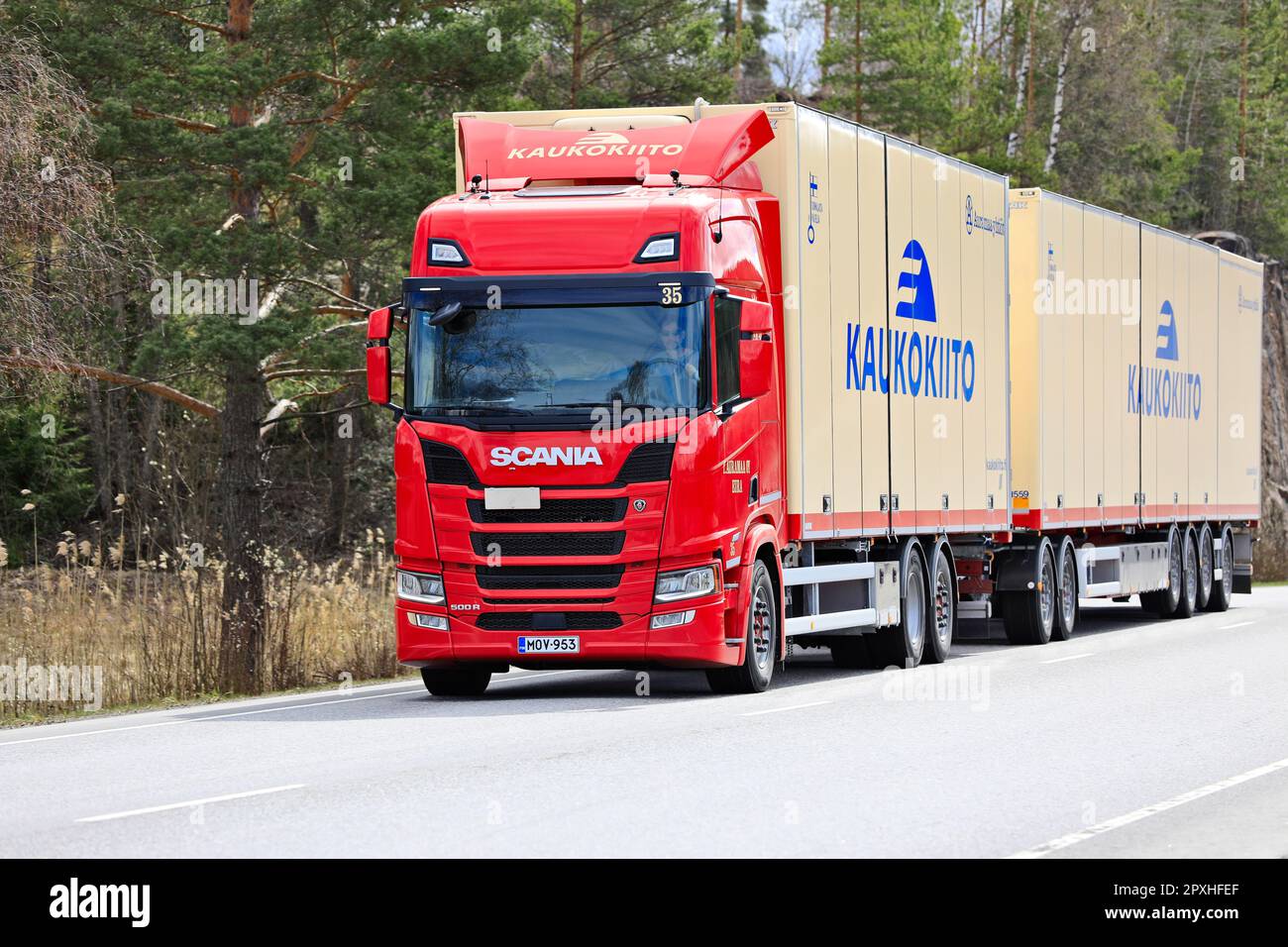 Red Scania 500R truck Kaukokiito pulling high capacity transport trailer in traffic on road 52. Salo, Finland. April 27, 2023. Stock Photo