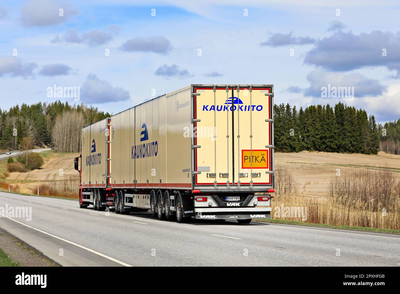 Scania truck Kaukokiito pulling high capacity transport trailer in traffic on road 52, rear view. Salo, Finland. April 27, 2023. Stock Photo