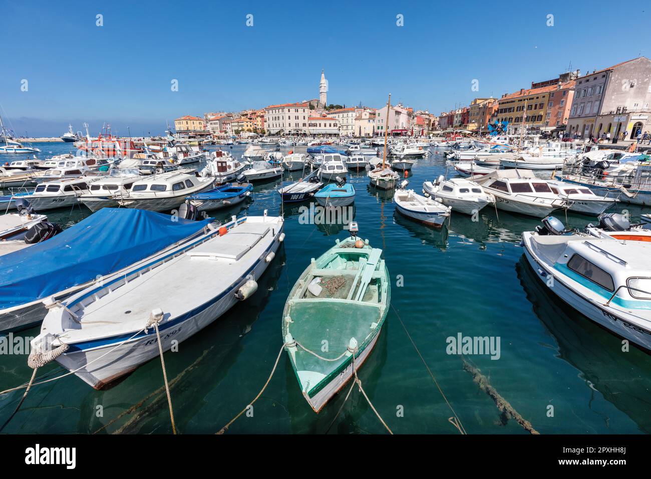 Boats moored in medieval Old Town harbour and marina in Adriatic Sea fishing port with historic  houses, shops, cafes, bars. Stock Photo