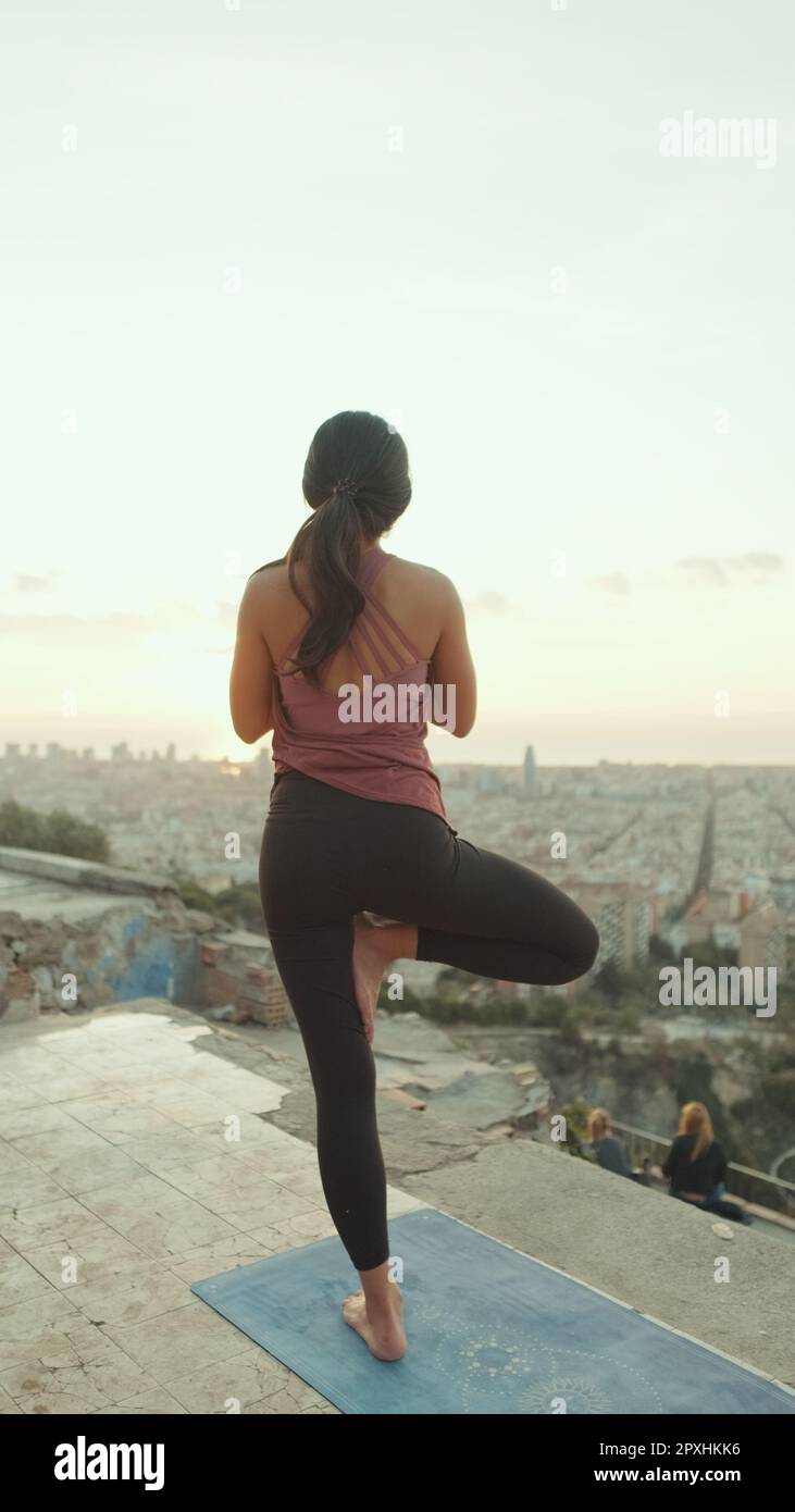 Girl practices yoga stands on one leg at lookout point at dawn, Back view Stock Photo Alamy