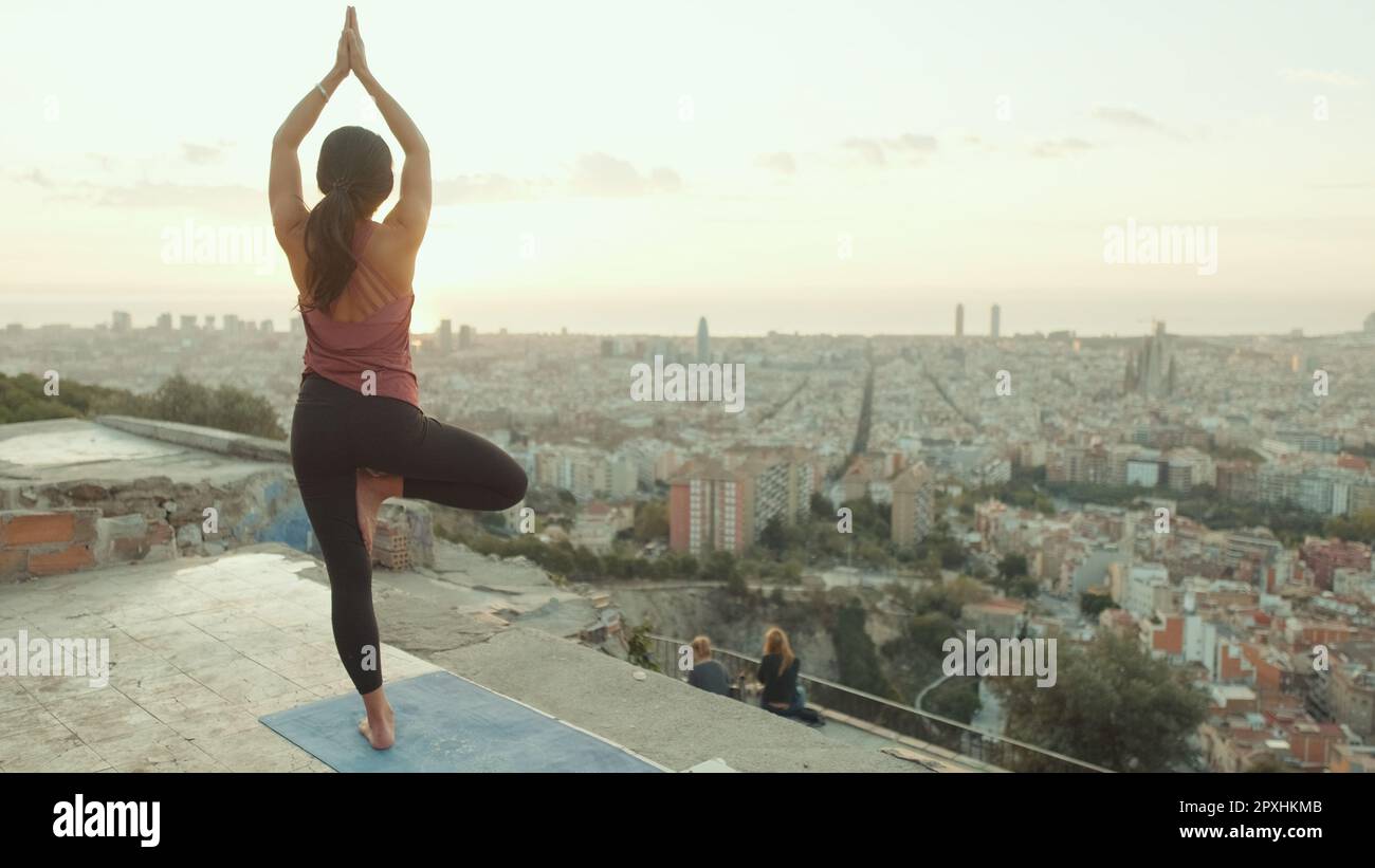 Girl practices yoga stands on one leg at lookout point at dawn, Back view Stock Photo Alamy