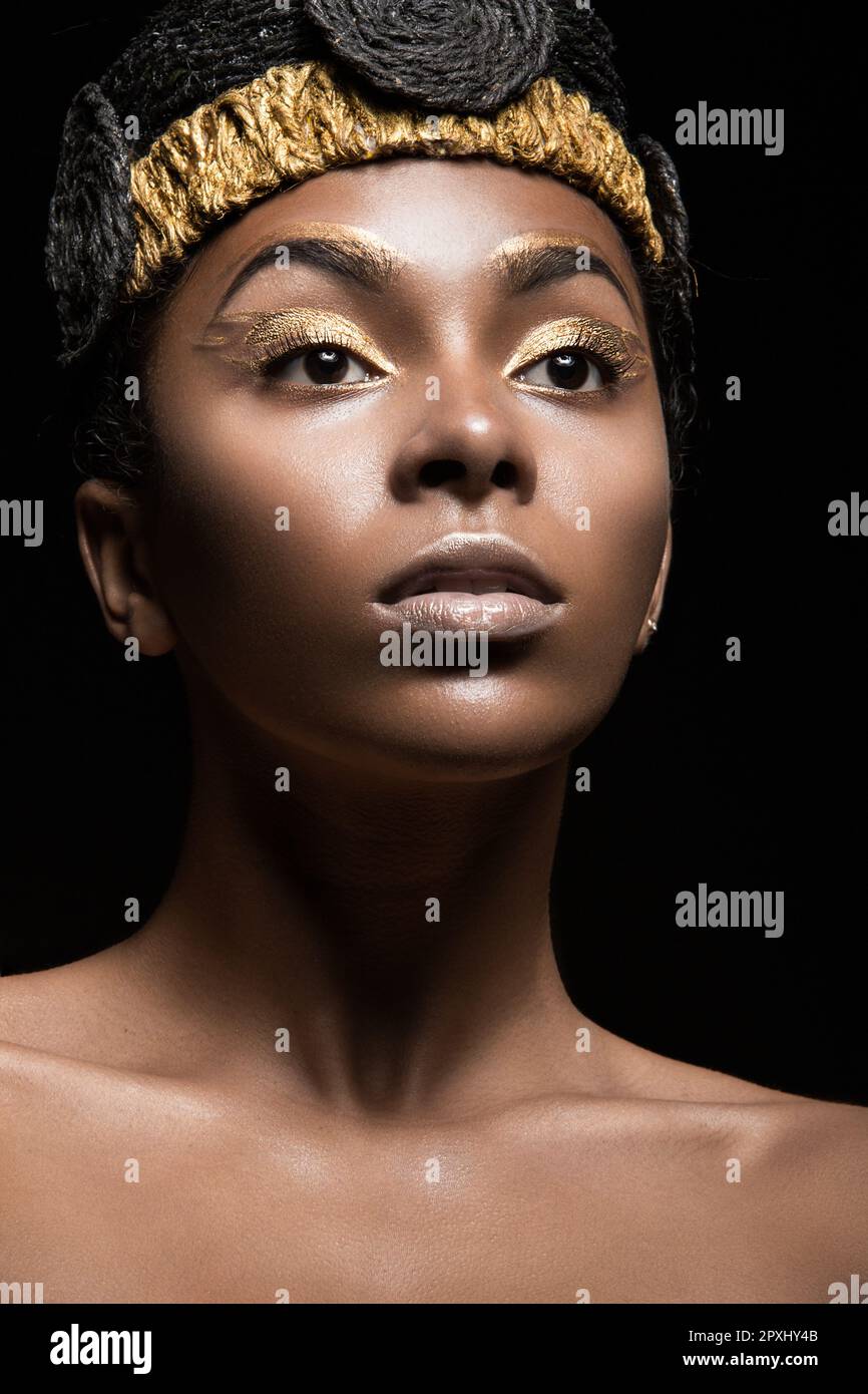 African girl with bright makeup and creative gold accessories on the head.  Beauty face. Picture taken in the studio on a black background Stock Photo  - Alamy