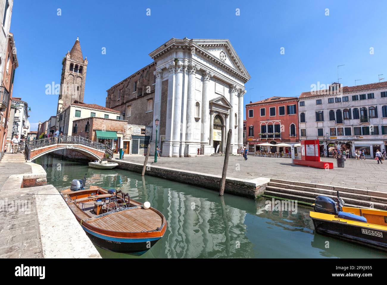 Boats on Rio de San Barnaba canal with Fondamenta Alberti (left) and St Barnabas bridge with Church of St Barnabas and bell tower, Dorsoduro, Venice Stock Photo