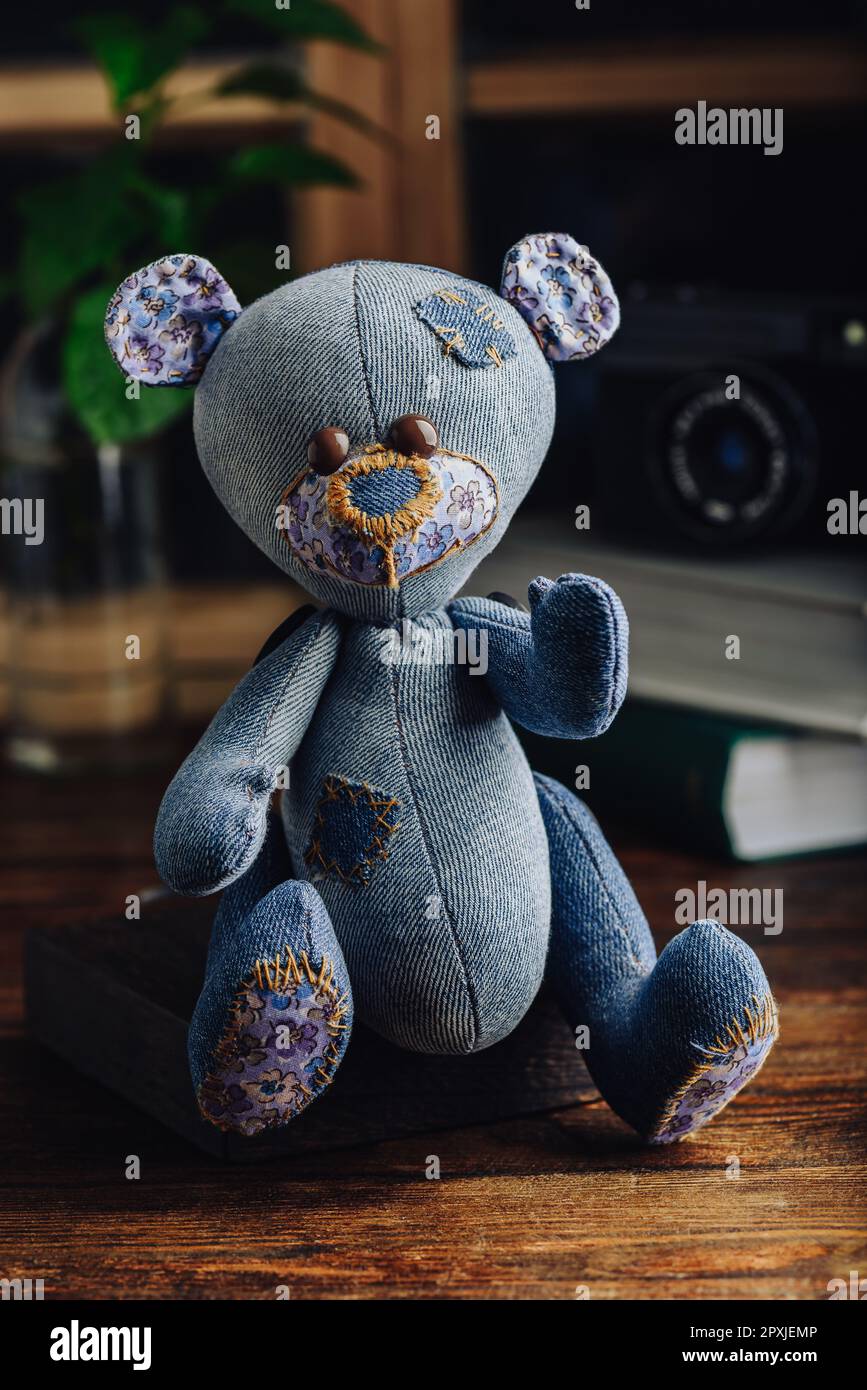 Blue Handmade Stuffed Bear Toy Sitting on Wooden Surface Stock Photo