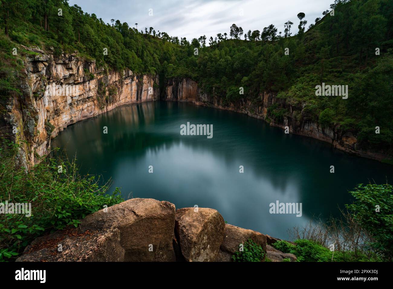 The ancient volcano crater with emerald color lake, surrounded by firs in the center of Madagascar Stock Photo