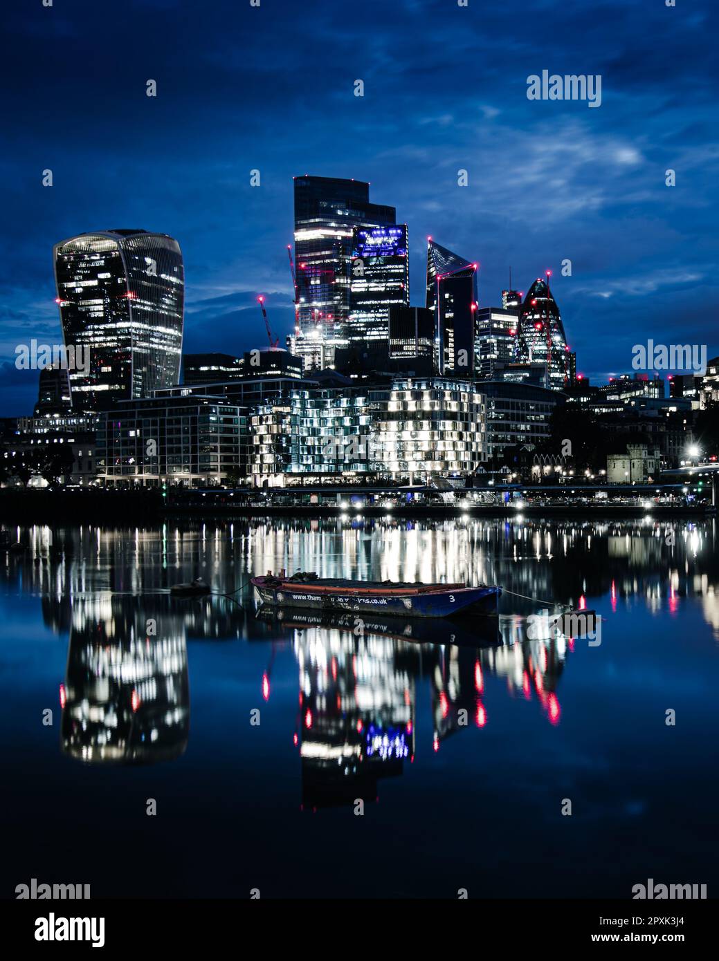 An illuminated nightscape of London, England, featuring a riverboat ...