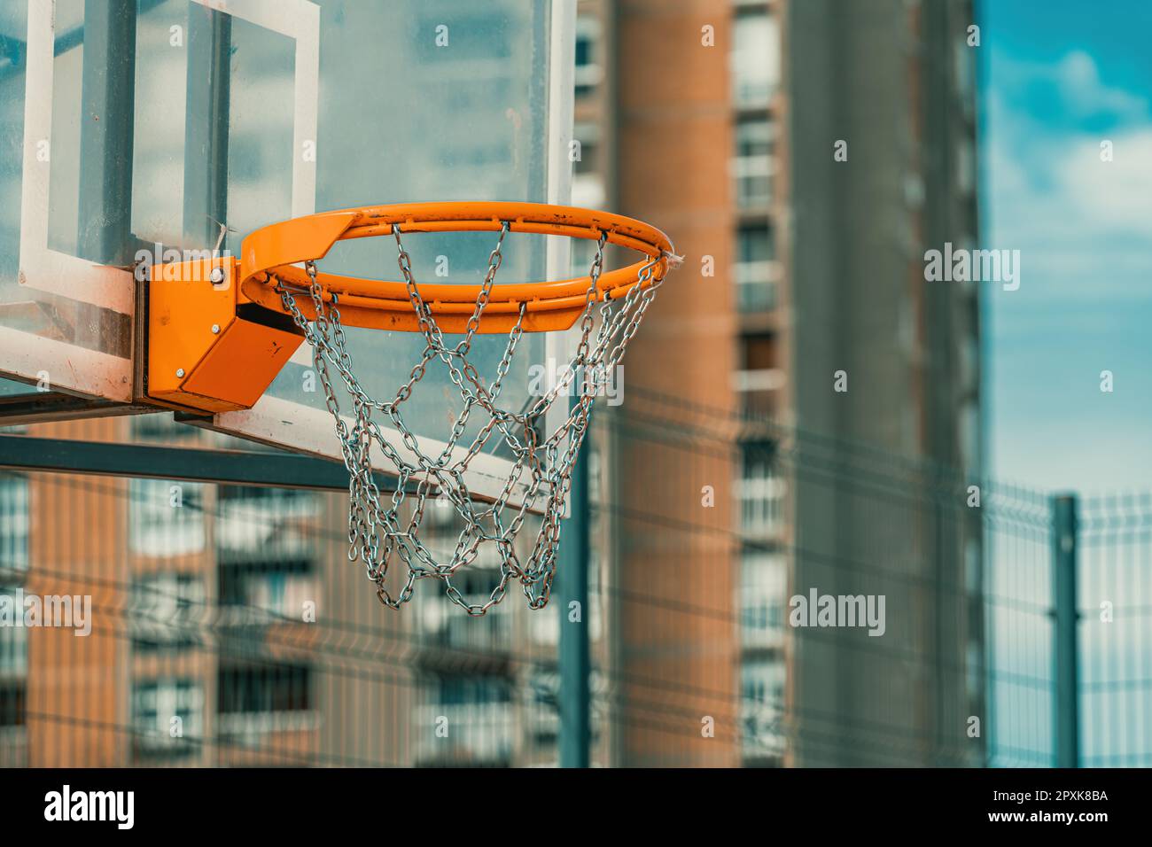 Outdoor basketball backboard and hoop rim with chain net in urban residential district
