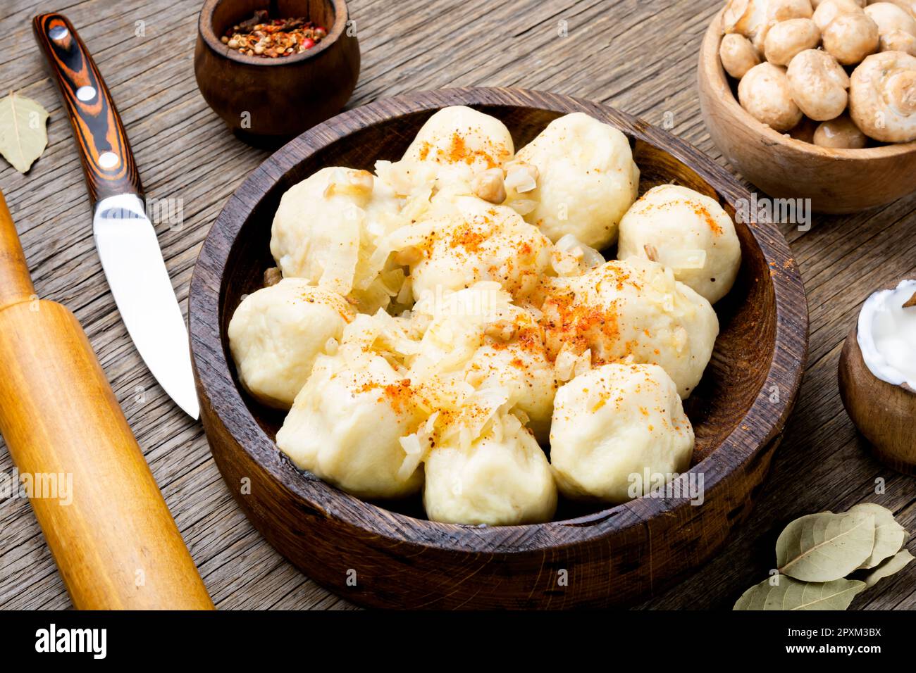 Knedliks, a boiled product made from dough, potatoes with mushroom filling on rustic the table Stock Photo