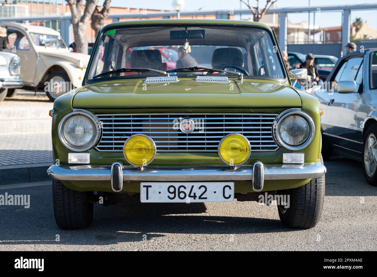 Detail of a classic Spanish car, it is a Seat 124 with round headlights, it is green Stock Photo