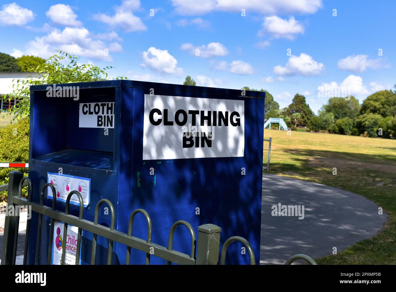 A recycling clothing bin situated in a fenced area surrounded by trees Stock Photo Alamy