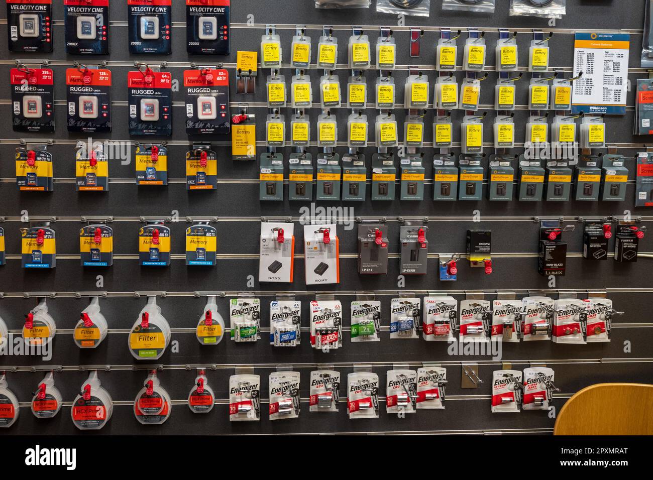 Goods on display in racks on the wall in a camera shop. Stock Photo