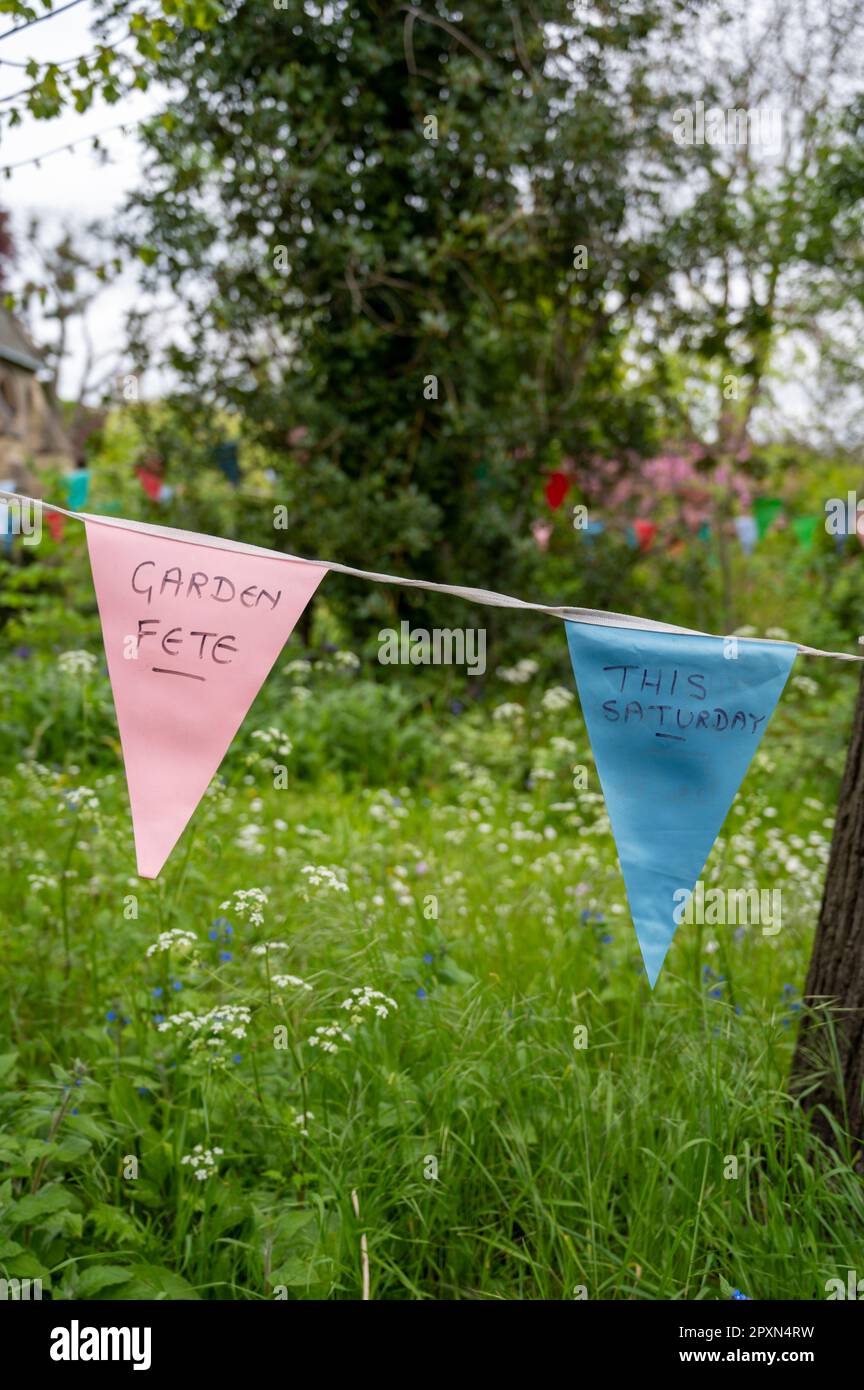 A bunting for a garden fete hanging in a garden in summer in England. Stock Photo