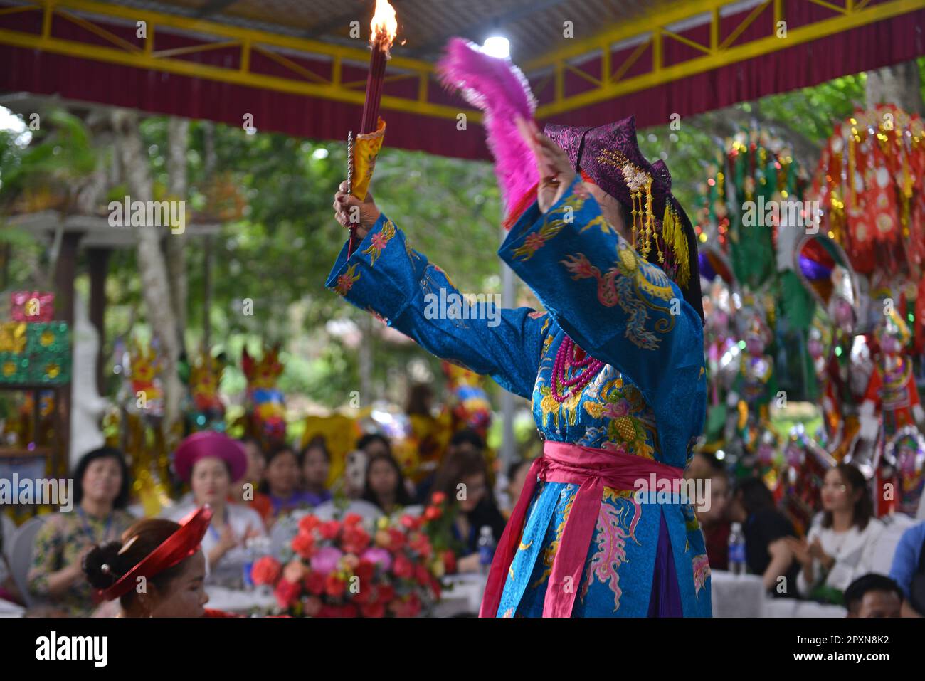 Shaman plays the role of a god performing rituals to transmit messages in Mother Goddess Worship event. North Vietnam. hầu đồng. 越南旅游, 베트남 관광, ベトナム観光 Stock Photo