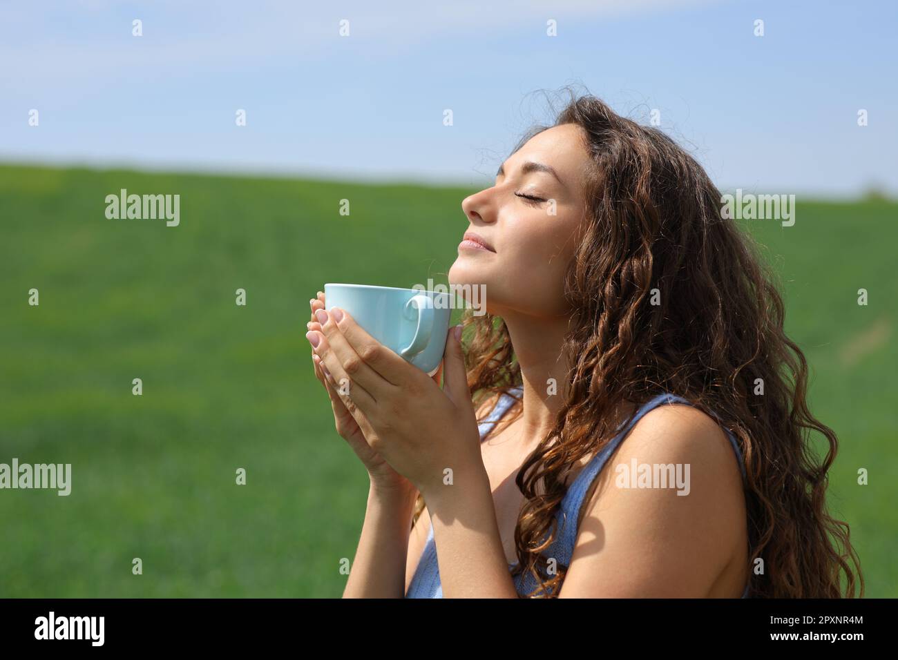 Woman breathing and smelling coffee outdoor in a field Stock Photo - Alamy