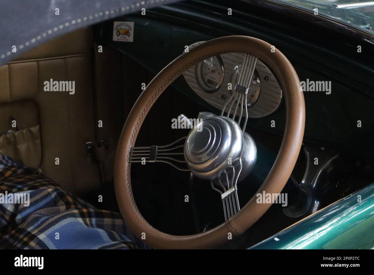 A classic car steering wheel featuring a wooden-like grip Stock Photo