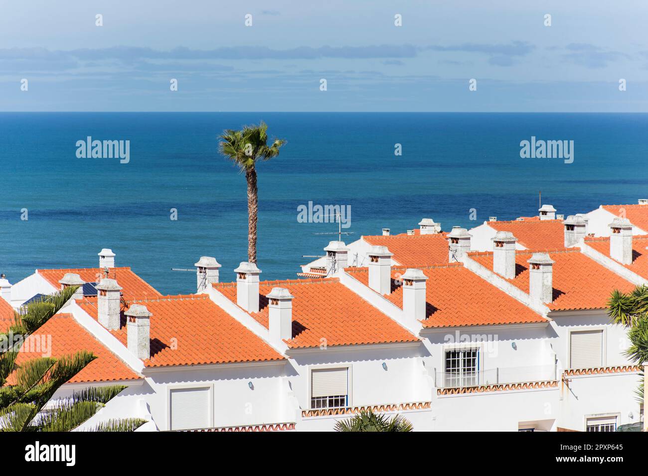 Atlantic Ocean and white-walled houses, seen from above. Casal do Carido, Ericeira. Portugal Stock Photo