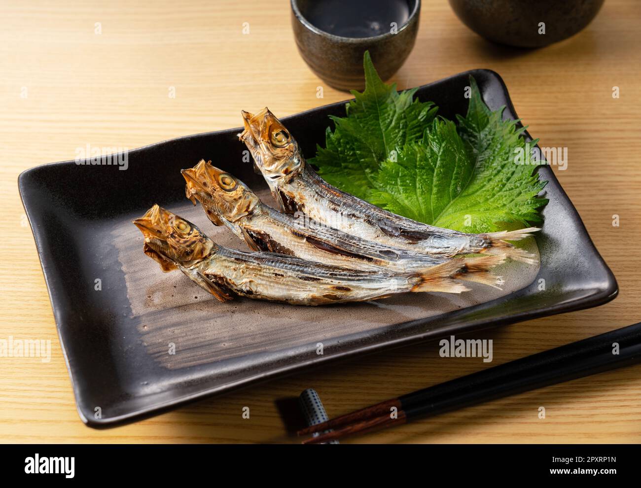 Grilled urume sardine placed on the table. A side dish of sake