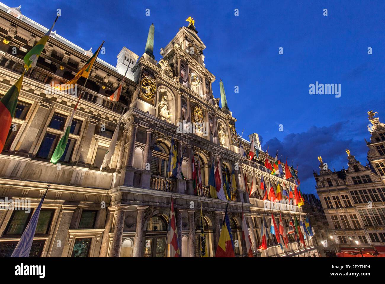 Historic renaissance style town hall, stadhuis, from 16th century with flags at twilight in Grote Markt, Old Town, Antwerp. UNESCO world heritage site Stock Photo