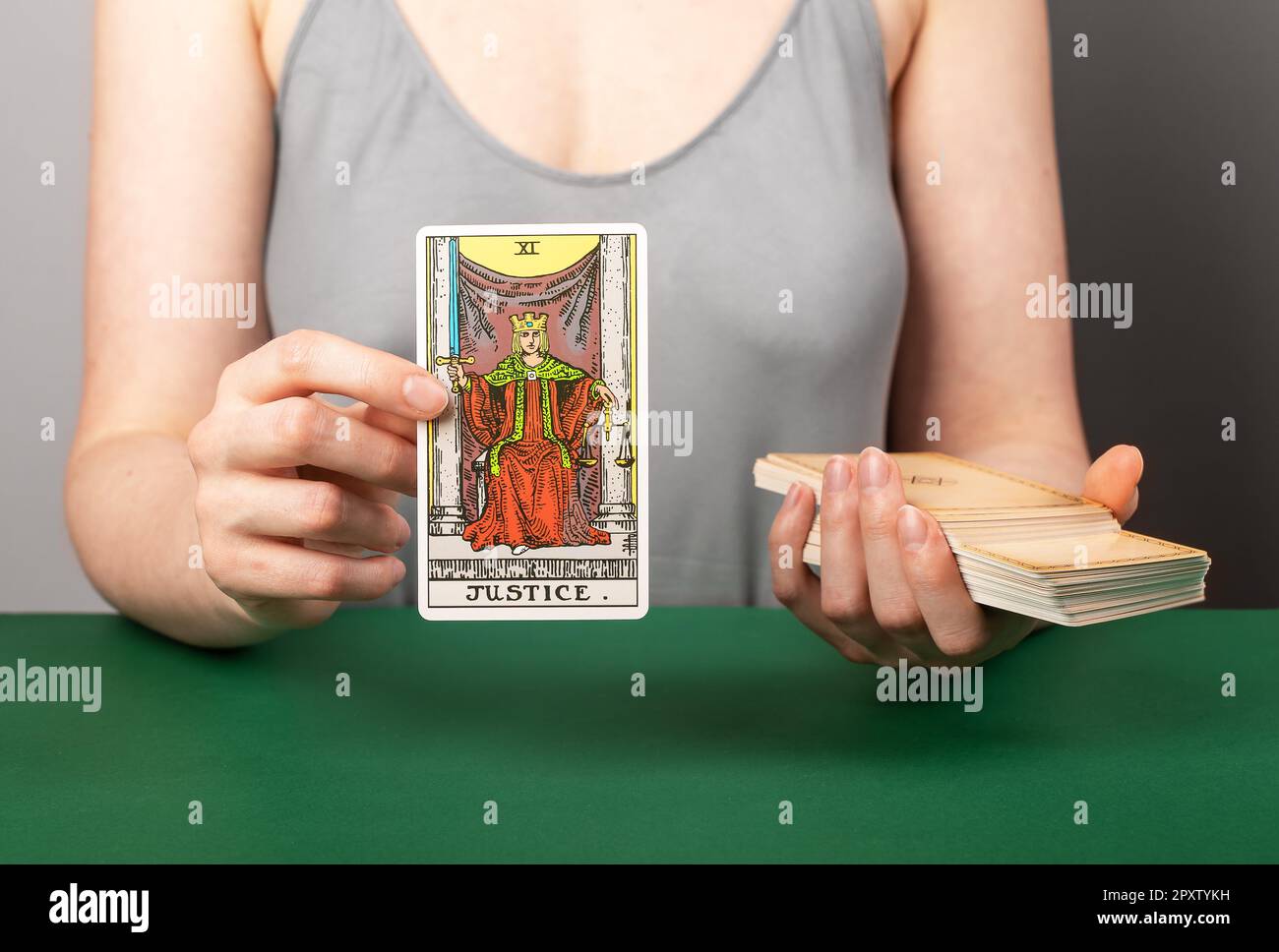 Lodz Poland April 15 2023 Justice arcana, hand holding showing tarot card during divination. Stock Photo