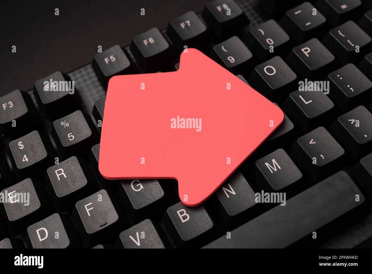 Sticker lying on black keyboard. Important message written over paper ...