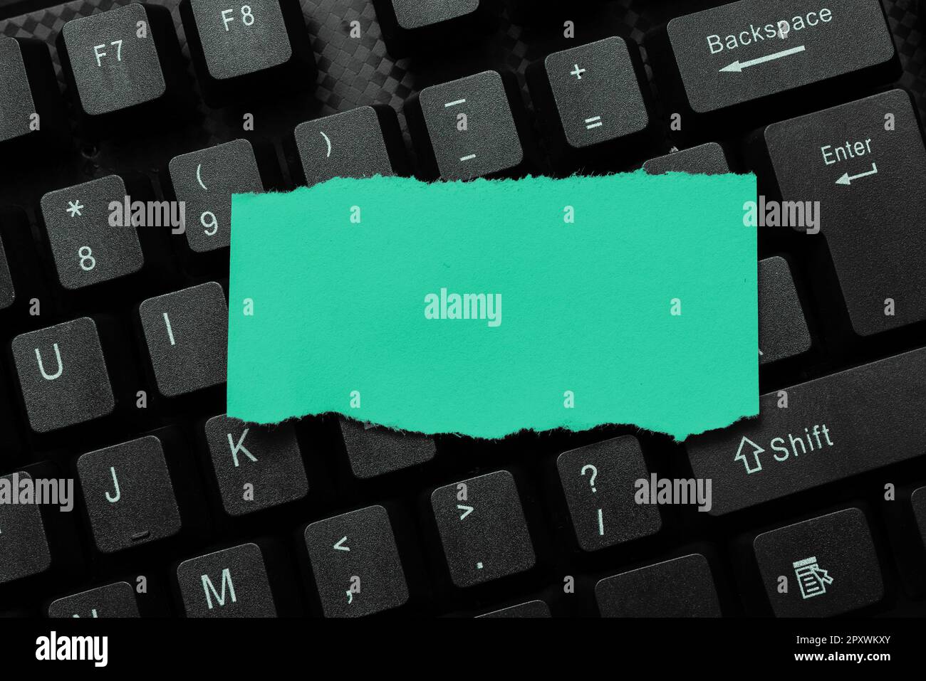 Colored sticker lying on keyboard. Important message written over paper. Stock Photo