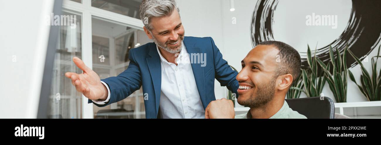 Two multiethnic business colleagues working together in modern office Stock Photo