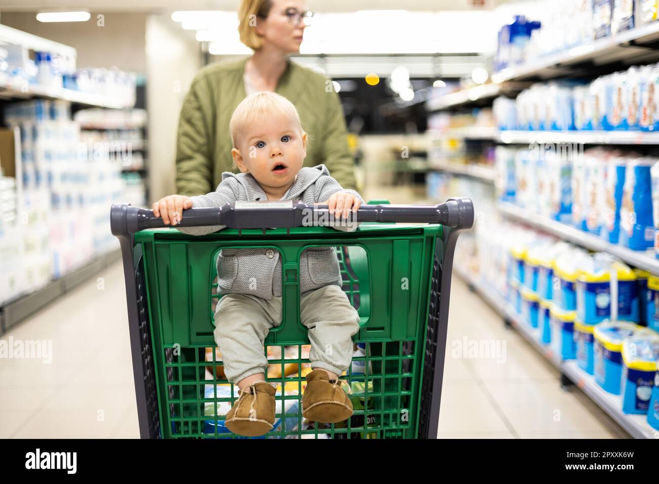 Baby pushing on sale shopping cart