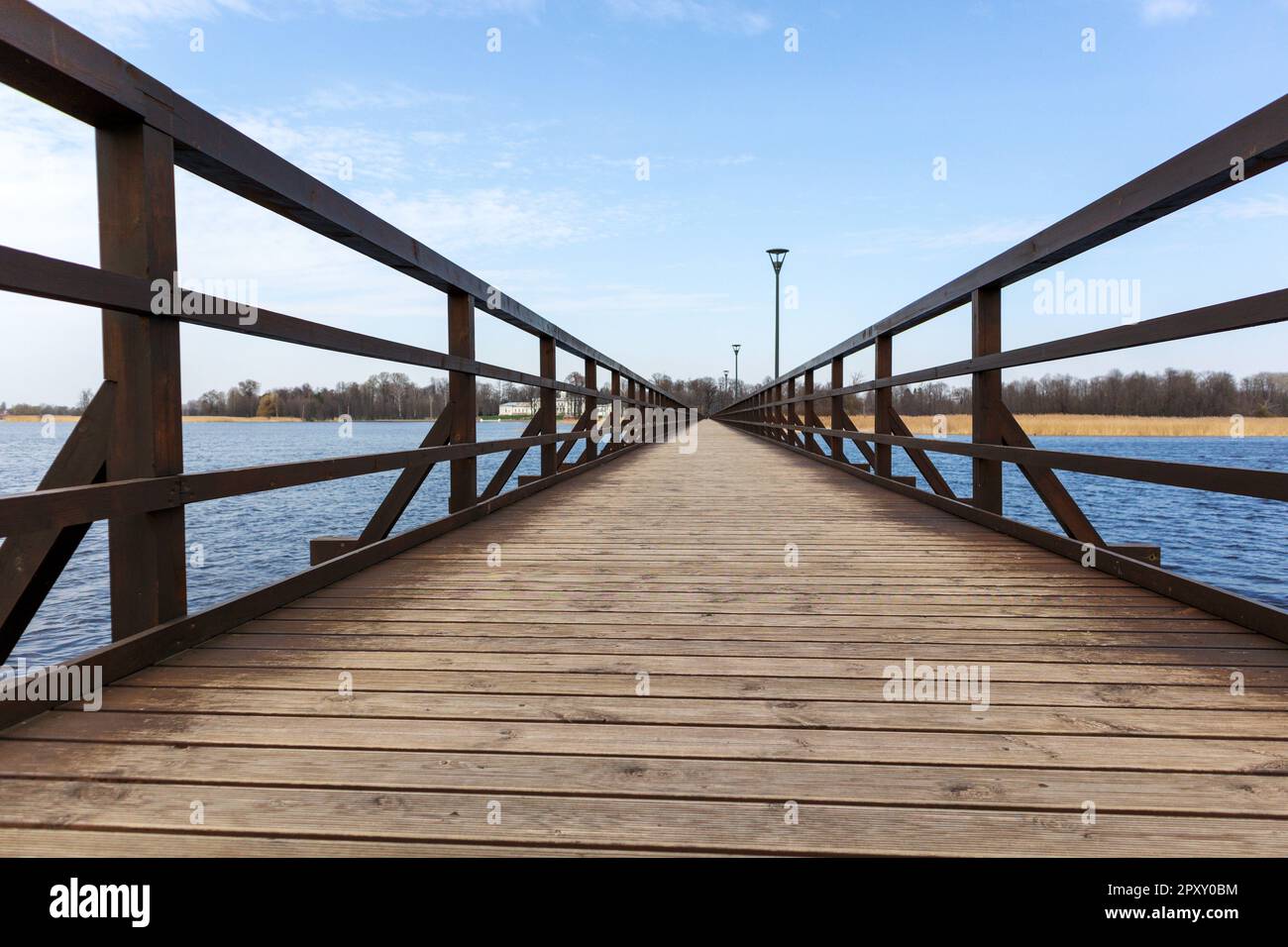 A wooden pier with a blue sky and clouds Stock Photo