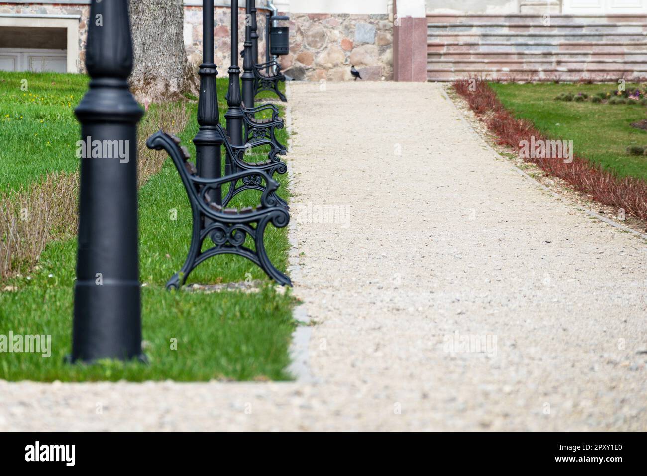 A sidewalk with a row of street lamps and benches on it Stock Photo - Alamy