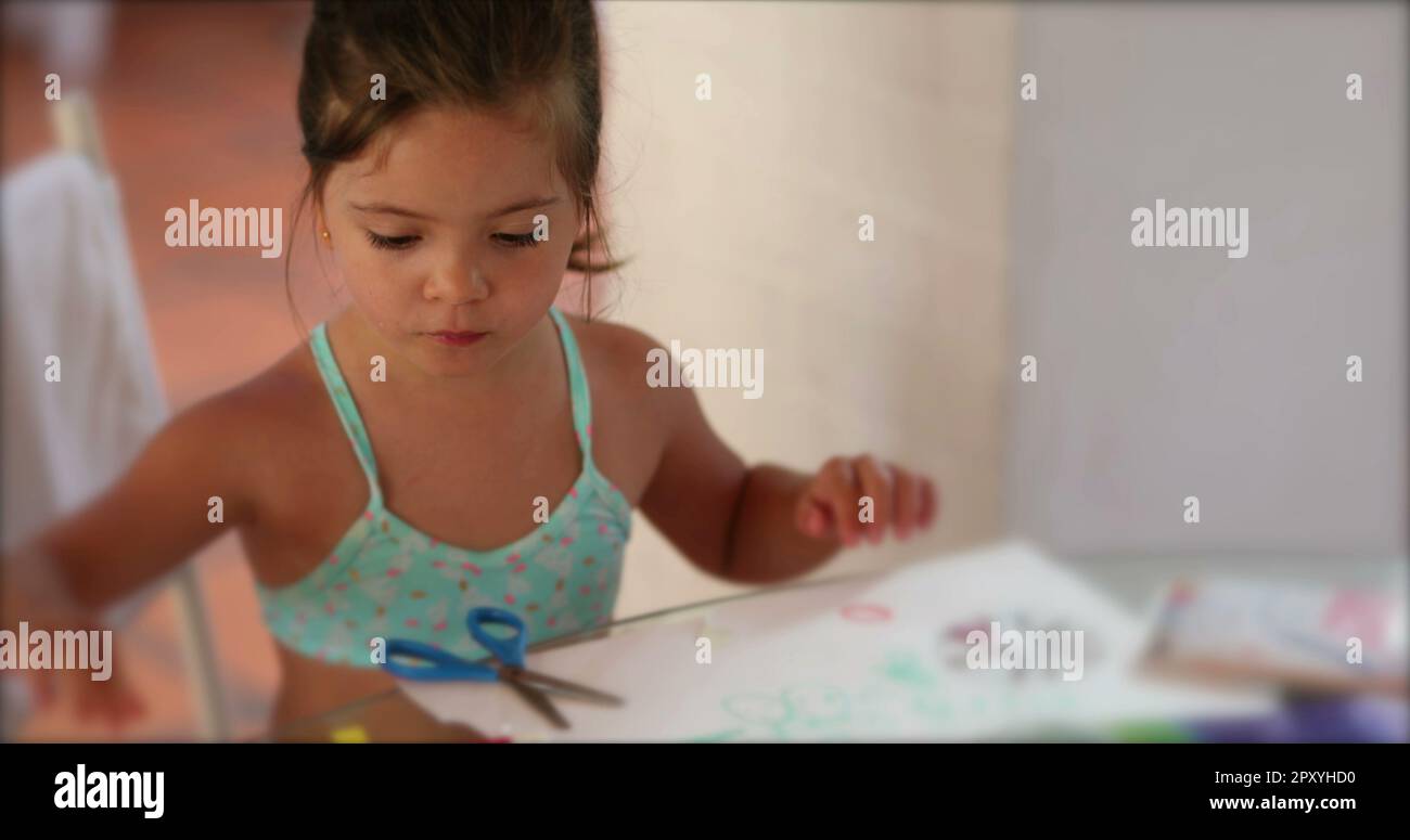 Creative little girl child drawing and crafting at home playing Stock Photo