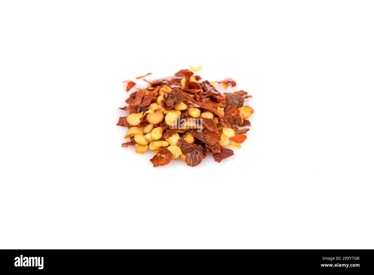 The pile of a crushed red pepper, dried chili flakes and seeds isolated