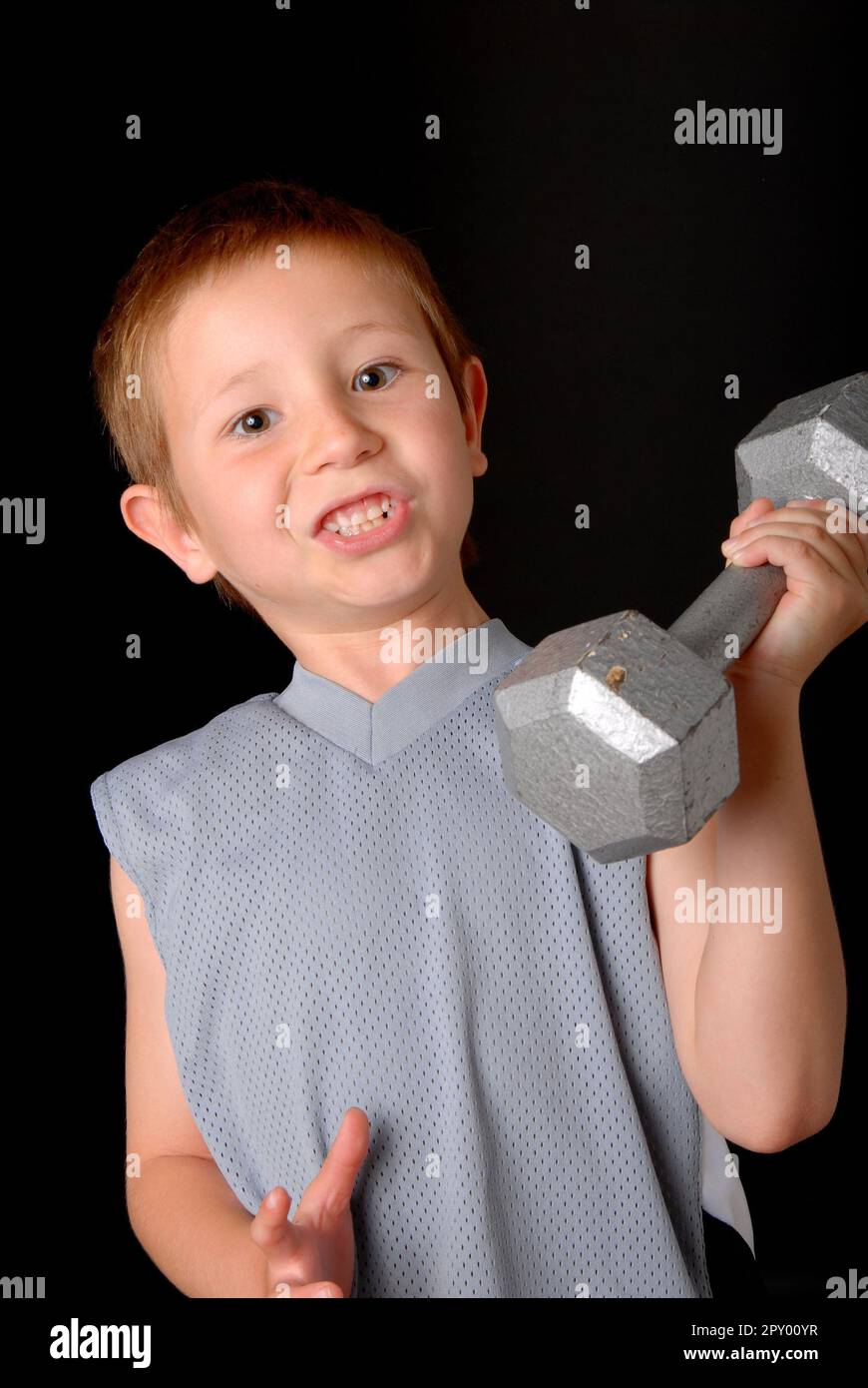 Young boy lifting weight that is too heavy Stock Photo Alamy