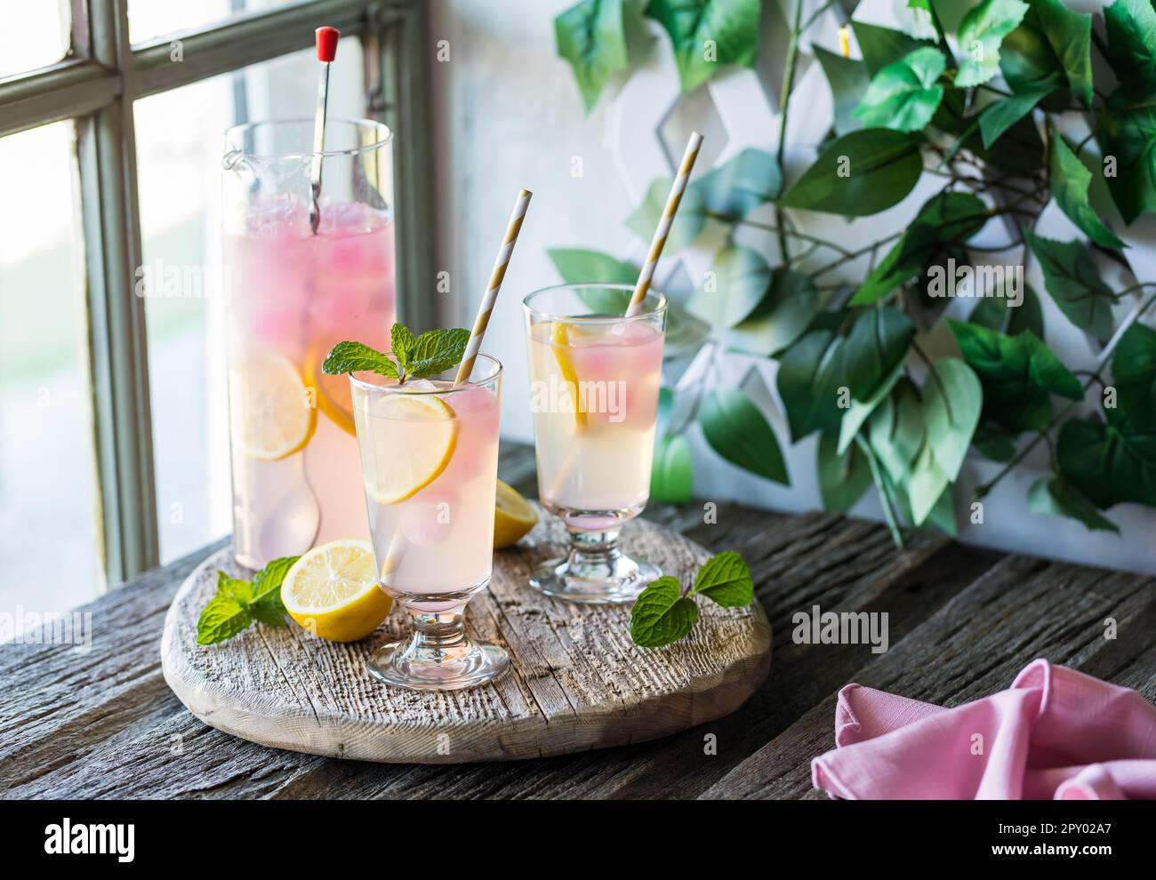 Cold and refreshing lemonade with pink lemonade ice cubes, ready for sharing. Stock Photo