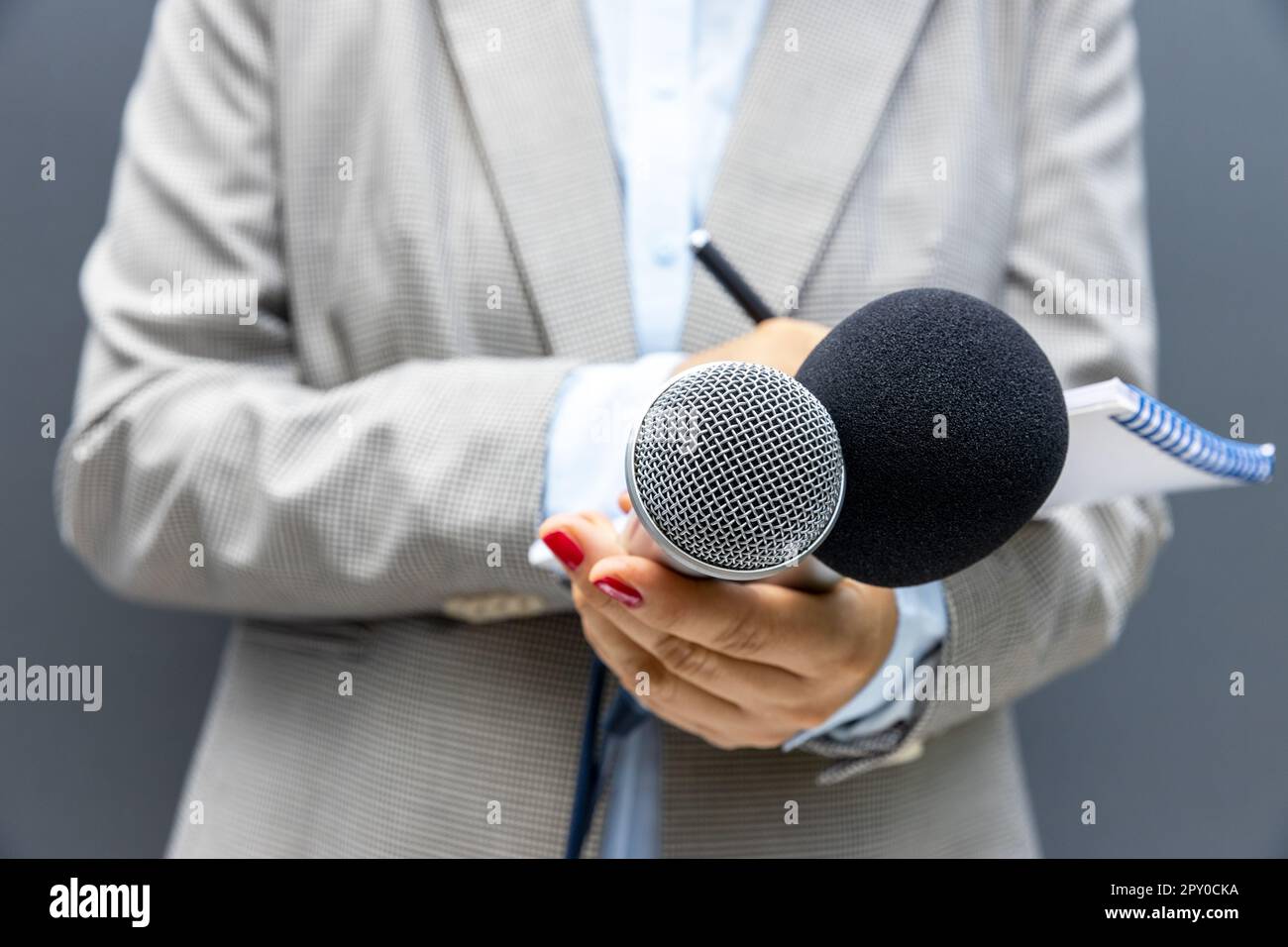 Female reporter at news conference or media event, writing notes ...